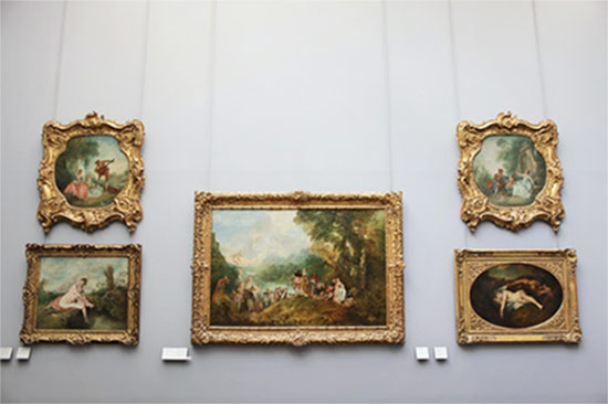 Framed paintings displayed on a gallery wall.